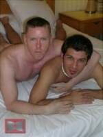 Austin Edwards with his arm around Latino Adrian R. on the bed - a quiet moment together